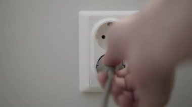 Kadın el duvar prizine güç fişleri koyar. 4k