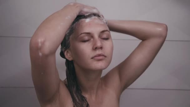 Frau wäscht Kopf unter der Dusche — Stockvideo
