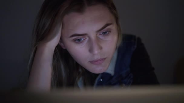 Σοβαρή, όμορφη κορίτσι δουλεύει με φορητό υπολογιστή τη νύχτα — Αρχείο Βίντεο