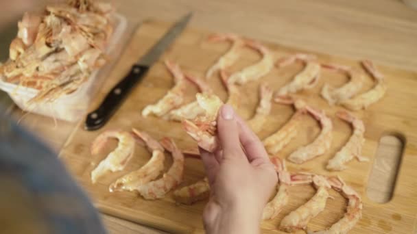 Γυναικεία χέρια ξεφλουδίζει πολλές γαρίδες για το μαγείρεμα — Αρχείο Βίντεο