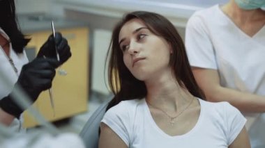 Young pretty girl sits in dental cabinet on treatment and consultating