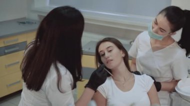 Gülümseyen kız tedavi ve danışmanlık diş dolabında oturur
