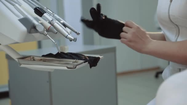 Zahnärztin zieht medizinische Handschuhe am Stuhl an — Stockvideo