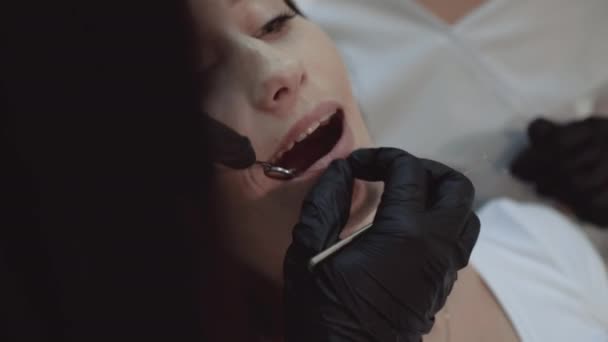 Joven chica bonita se sienta en el gabinete dental en el tratamiento y consultoría — Vídeos de Stock