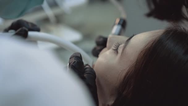 Mooi meisje liggend op tanden reinigende behandeling. 4k. — Stockvideo