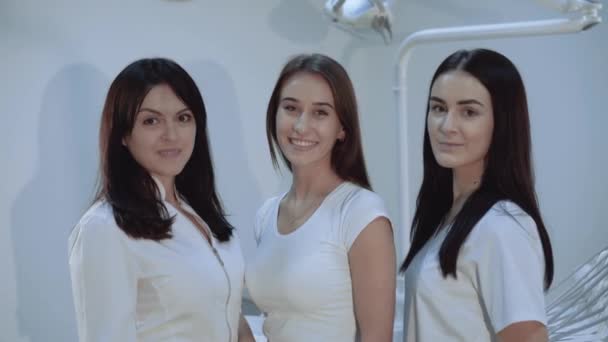 Портрет щасливих, впевнених стоматологів дивиться на камеру в стоматологічній кімнаті — стокове відео
