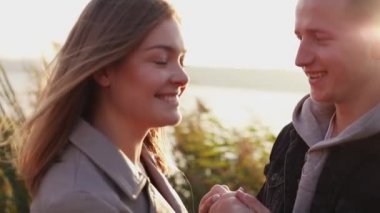 Mutlu çift gülümsüyor, el ele tutar ve bir sokakta öper