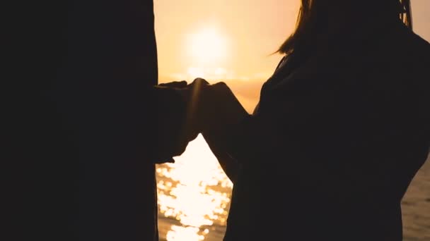 Večerní silueta roztomilá dvojice stojí u jezera s záři slunce — Stock video