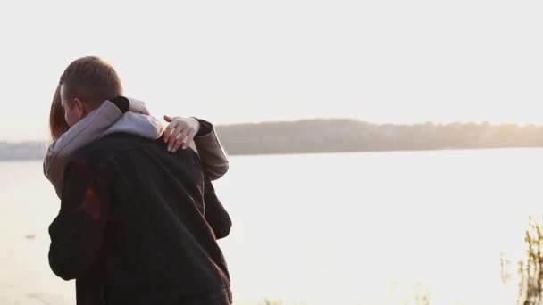 Romantisch paar draait rond in omhelzingen in de avond Sunny Lake — Stockvideo