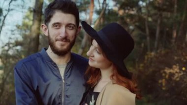 Bir parkta aşık mutlu çift: gülümseme ile kolay öpücük. 4k