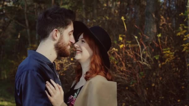 Романтична пара посміхається і легко цілується один з одним в парку — стокове відео