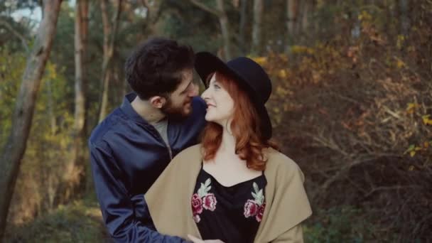 Lächelnder Mann umarmt sein posierendes Mädchen und küsst im Frühlingspark — Stockvideo