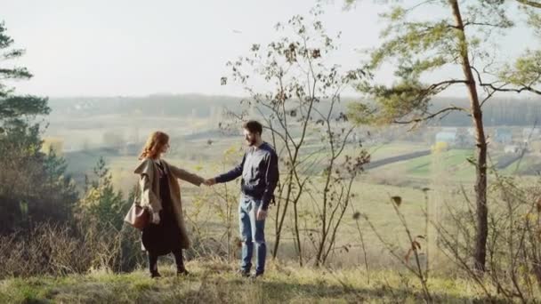 Портрет влюбленной счастливой пары стоит на склоне и смотрит вдаль — стоковое видео