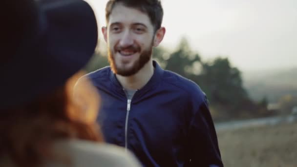 행복한 남자와 여자는 저녁 자연에 기쁨으로 서로 키스 — 비디오