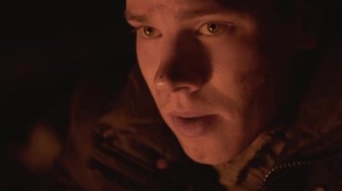 Yorgun evsiz adam ormanda kamp ateşi bir parça vahşi yiyecek yiyor