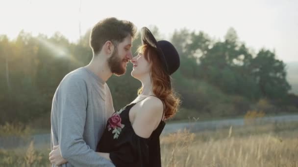 Sonriente pareja enamorada se besa y se acaricia en la soleada estepa — Vídeo de stock