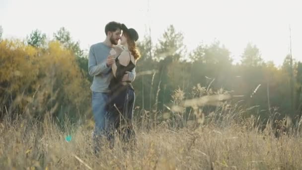Happy couple in love kisses and caresses each other in sunny steppe — Stock Video