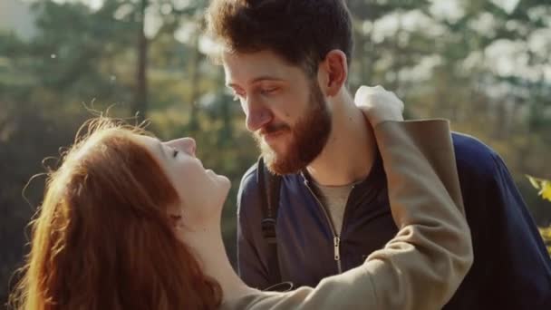 Glückliches Paar posiert im sonnigen Park in Umarmungen vor der Kamera — Stockvideo