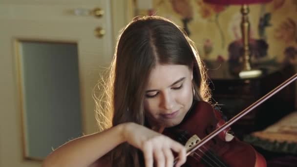 Guapa, pensativa, violinista tocando la melodía en el dormitorio — Vídeos de Stock