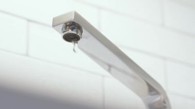 Beyaz kiremit arka plan üzerine damlama su damlaları ile Musluk