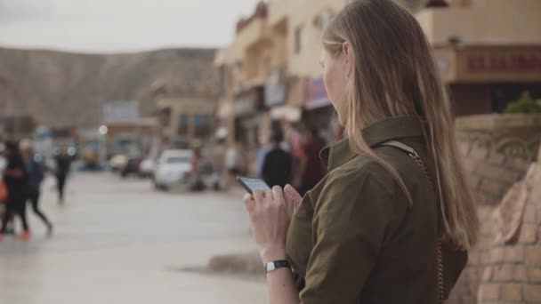 Красивая беременная женщина пользуется смартфоном в мечети и осматривается вокруг — стоковое видео