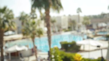 Palmiye ağaçları ve yüzme havuzu ile tatil köyünün dışı bulanık