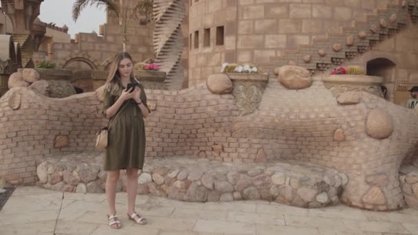 Mulher muito grávida usando smartphone na mesquita — Vídeo de Stock