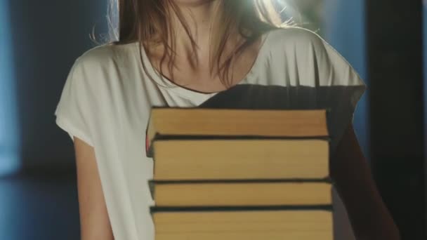 Πορτρέτο της κουρασμένης φοιτήτριας με γυαλιά κρατά μια στοίβα από βιβλία στην κάμερα — Αρχείο Βίντεο