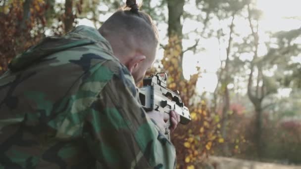 Kamuflajlı bir askerin çok yönlü görüntüsü tüfek görüşlü bir nesneyi takip ediyor. — Stok video