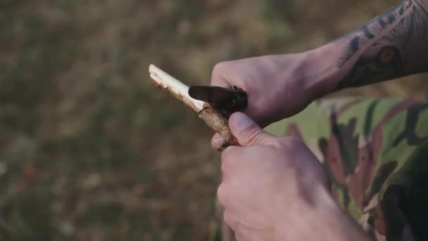 칼로 나무 조각품을 날카롭게 깎고 있는 잔인 한 남자 손 — 비디오