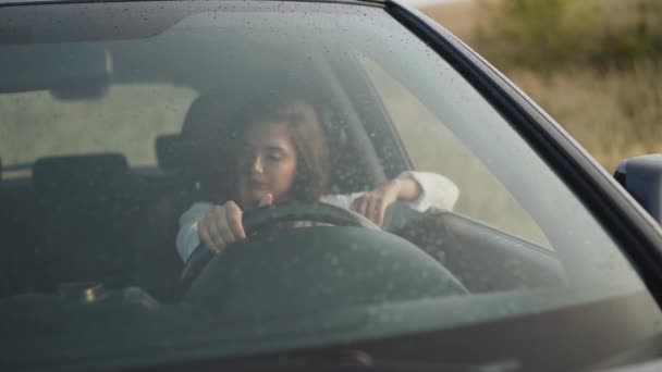 View through the windscreen of worried girl in car is nervous and waits — Stock Video