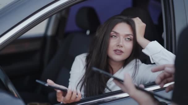 Fille émotionnelle en voiture parlant avec quelqu'un avec tablette et souriant — Video