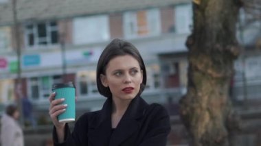 Bir fincan kahveli düşünceli bayan sokağa bakıyor.