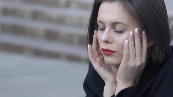 Mused vrouw zitten op straat trap en leunen haar hoofd op handen — Stockvideo