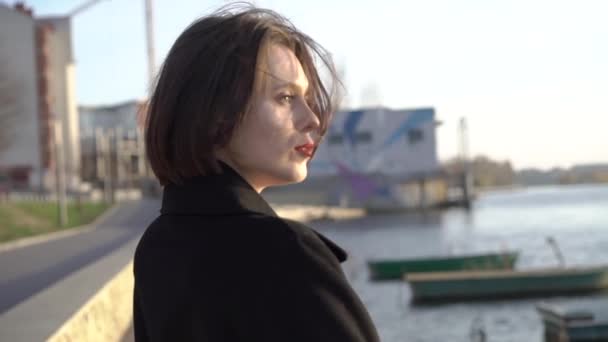 Портрет страстной брюнетки с ветреными волосами и красными губами смотрит в камеру — стоковое видео