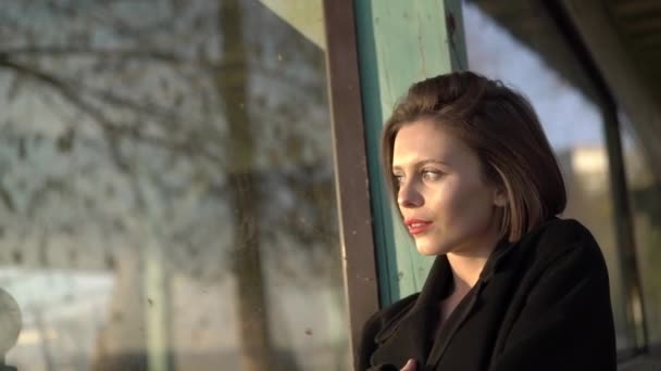 Portrét svůdné brunetky se zabalí do kabátu a pózuje v domě — Stock video