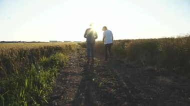 Tarlaya gidip kendi aralarında konuşan iki çiftçi.