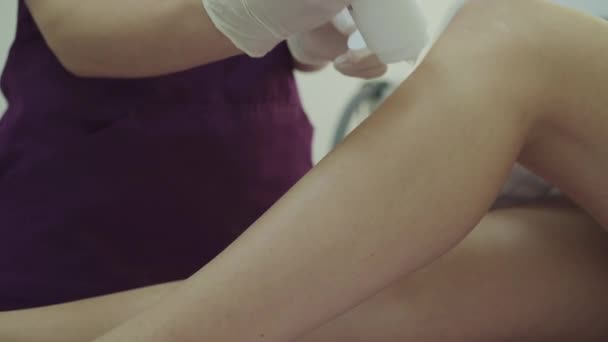 Application de gel avant épilation au laser sur les jambes avec spatule jetable — Video