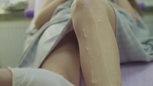 Gel spalmante con spatola monouso sulle gambe prima del trattamento di depilazione laser — Video Stock