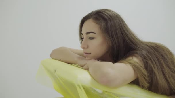 Retrato de una hermosa chica tumbada en un sofá durante el tratamiento en un salón de belleza — Vídeo de stock