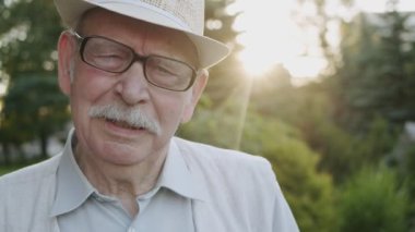 Mutlu kıdemli adam duygusal olarak nefes verir, sevinir ve parktaki kameraya şöyle der: