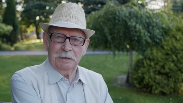 Πορτρέτο του κομψού ηλικιωμένου με γυαλιά στο καπέλο λέει ποιητικά στην κάμερα — Αρχείο Βίντεο