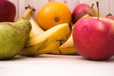 Çeşitli meyve elma, muz, portakal, nar doğal ahşap zemin üzerinde. Sağlıklı gıda