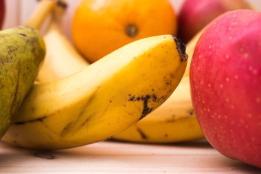 Çeşitli meyve elma, muz, portakal, nar doğal ahşap zemin üzerinde. Sağlıklı gıda