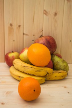 Çeşitli meyve elma, muz, portakal, nar doğal ahşap zemin üzerinde. Sağlıklı gıda