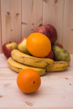 Çeşitli meyve elma, muz, portakal, nar doğal ahşap zemin üzerinde. Sağlıklı gıda