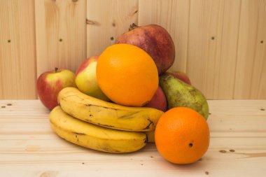 Çeşitli meyve elma, muz, portakal, nar doğal ahşap zemin üzerinde. Sağlıklı gıda