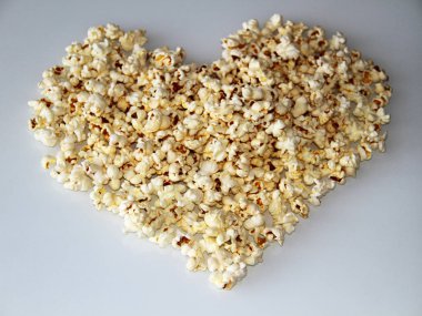 patlamış mısır beyaz bir arka plan üzerinde bir kalp şeklinde ortaya koydu