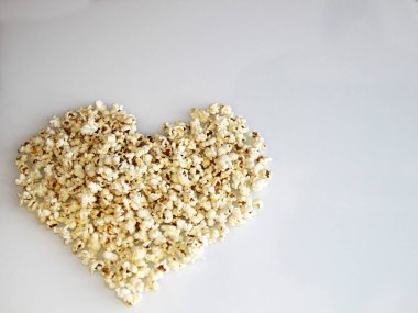 patlamış mısır beyaz bir arka plan üzerinde bir kalp şeklinde ortaya koydu