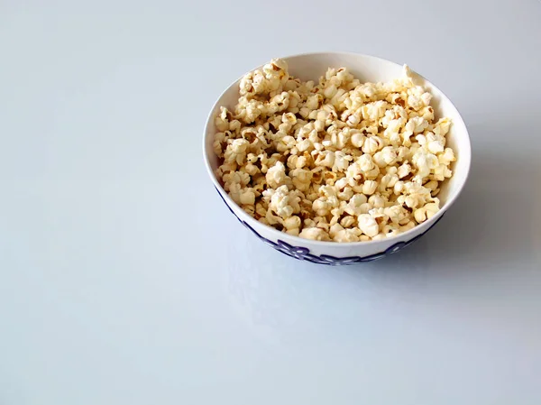 top view of a pile of popcorn caramel popcorn in a plate on a glass table